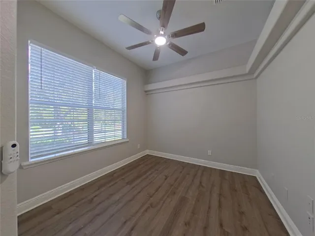 a view of a room with wooden floor and a ceiling fan