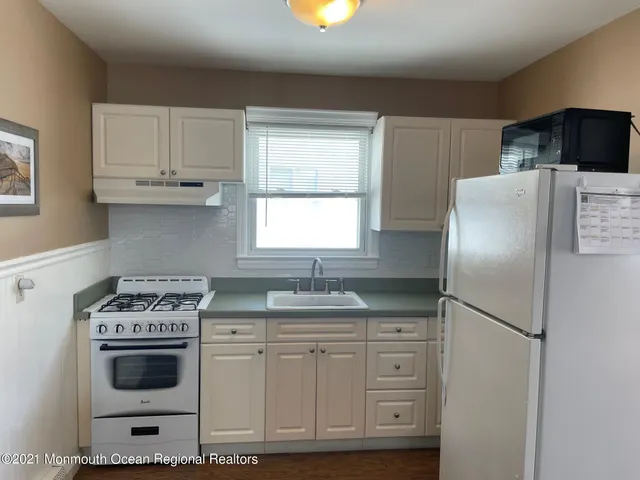 a kitchen with cabinets appliances and a window