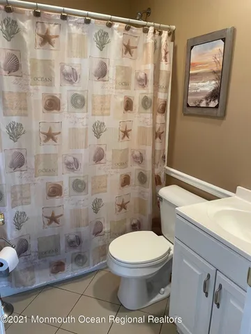 a white toilet sitting next to a shower curtain