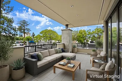 a roof deck with couches and potted plants