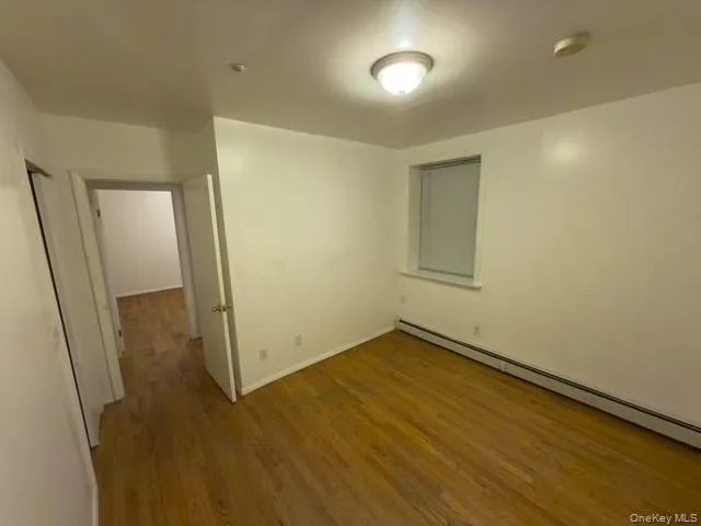 an empty room with wooden floor and mirror