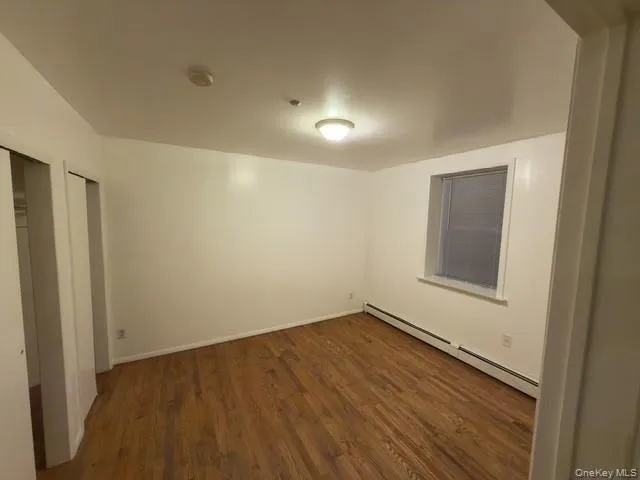 a view of a room with wooden floor and window