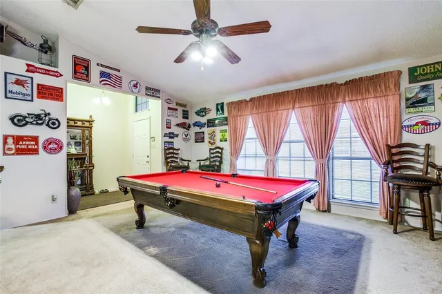 a room with pool table and windows
