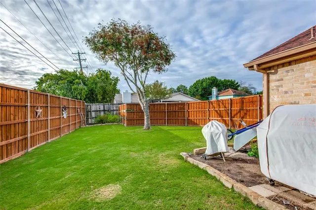 a view of a backyard with a garden and entertaining space