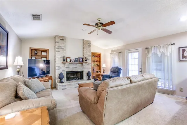 a living room with furniture a fireplace and a window