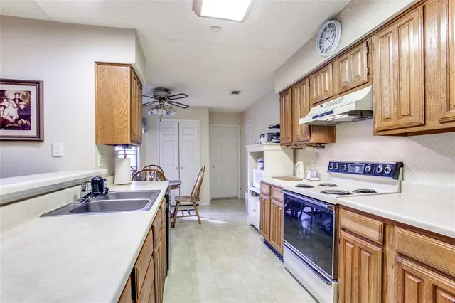 a kitchen with stainless steel appliances granite countertop a sink stove and cabinets