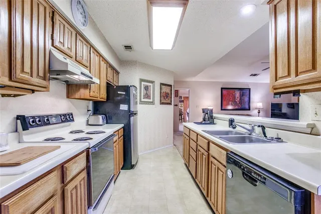 a kitchen with stainless steel appliances granite countertop a sink stove and cabinets