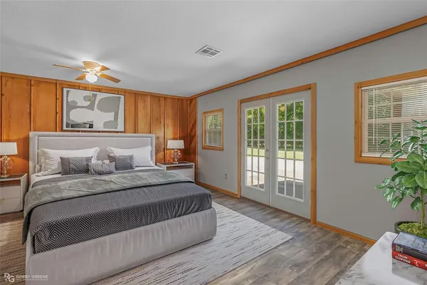 a bedroom with a large bed and wooden floor