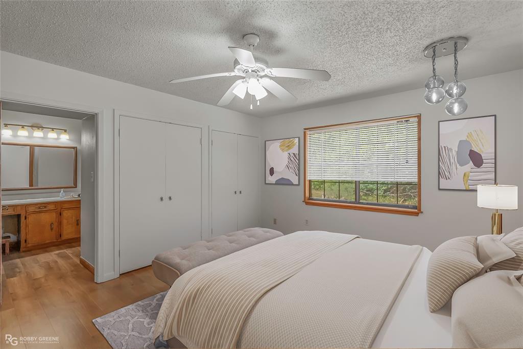 10307 Pirogue Road Oil City, LA 71061 - Photo 24 of 39 a bedroom with a bed and a chandelier