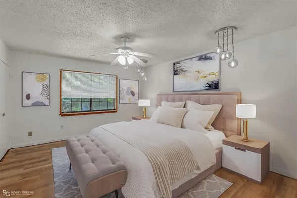 a bedroom with a bed and a painting on the wall