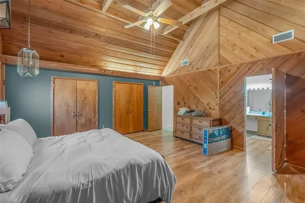 a bed sitting in a spacious bedroom next to a window