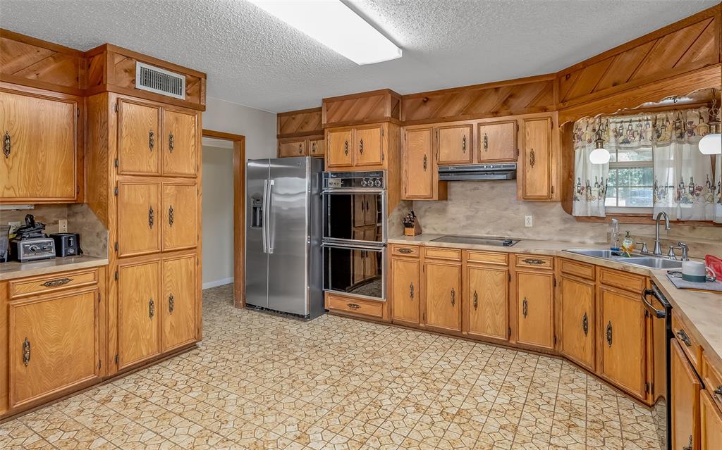 10307 Pirogue Road Oil City, LA 71061 - Photo 7 of 39 a kitchen with stainless steel appliances granite countertop a refrigerator a stove and a sink with cabinets