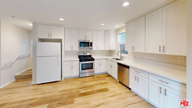 a kitchen with white cabinets and white appliances