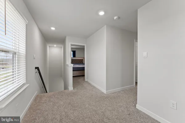 a view of hallway with stairs and wooden floor