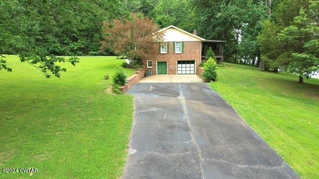 591 Asbury Road Camden, TN 38320 - Photo 32 of 38 a front view of a house with garden