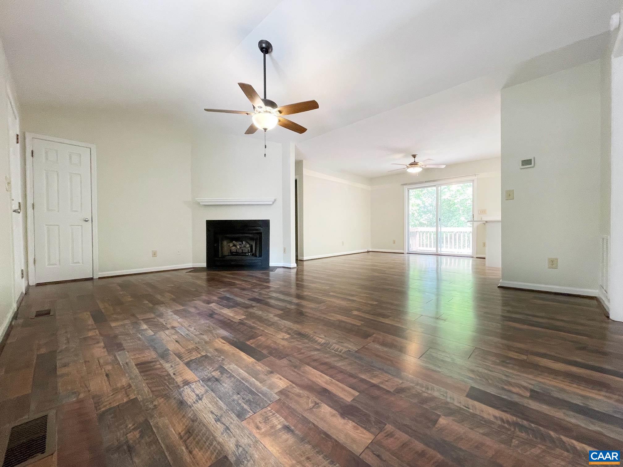 81 Phlox Road Ruckersville, VA 22968 - Photo 4 of 24 an empty room with wooden floor fireplace and fan