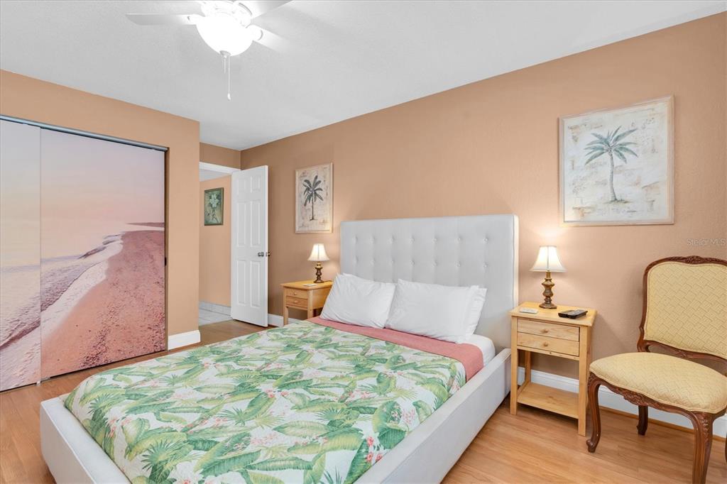 19610 Gulf Boulevard, Unit 308 Indian Rocks Beach, FL 33785 - Photo 16 of 41 a bedroom with a bed a chair and potted plant on the dresser