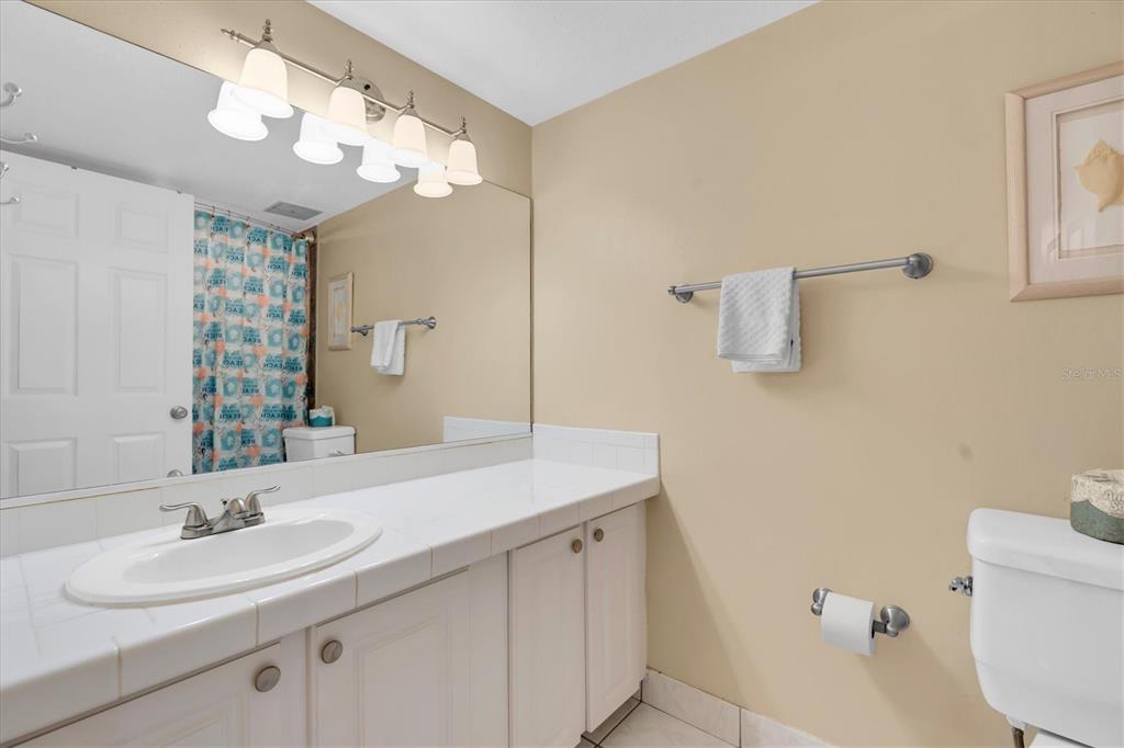 19610 Gulf Boulevard, Unit 308 Indian Rocks Beach, FL 33785 - Photo 22 of 41 a bathroom with a sink a toilet and a mirror