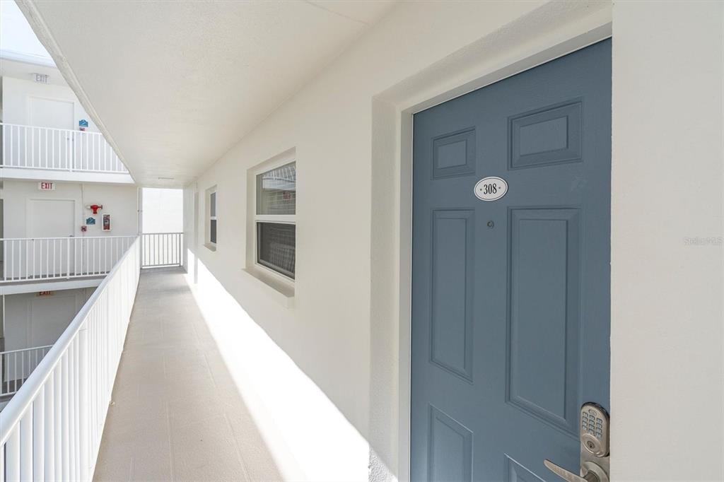 19610 Gulf Boulevard, Unit 308 Indian Rocks Beach, FL 33785 - Photo 4 of 41 a view of a hallway with wooden floor and staircase