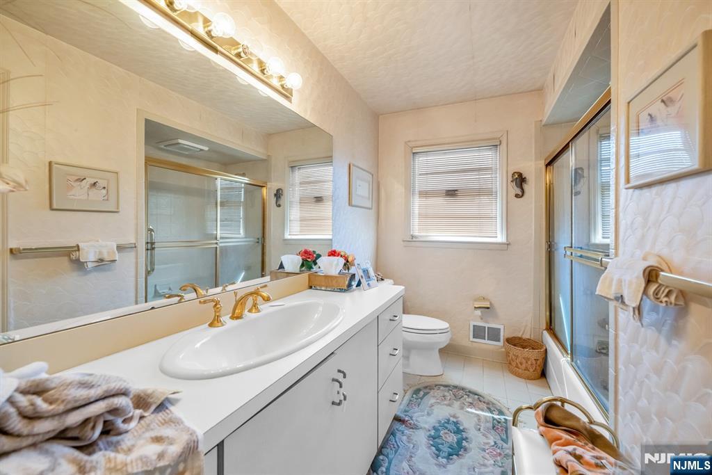 204 Tryon Place Paramus, NJ 07652 - Photo 18 of 33 a bathroom with a sink toilet vanity and mirror