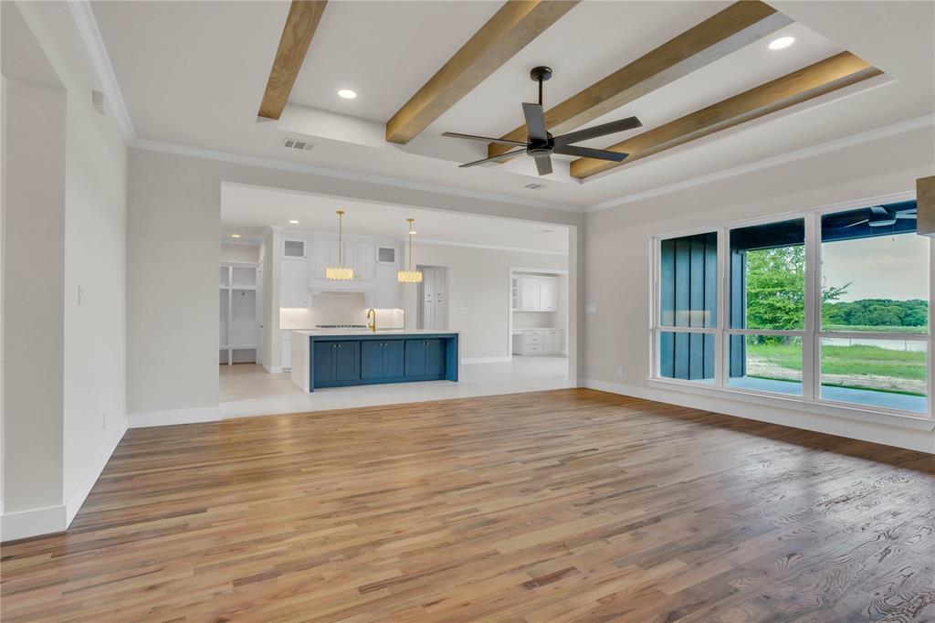 1028 Henry Way Springtown, TX 76082 - Photo 7 of 40 a view of an empty room with wooden floor and a window