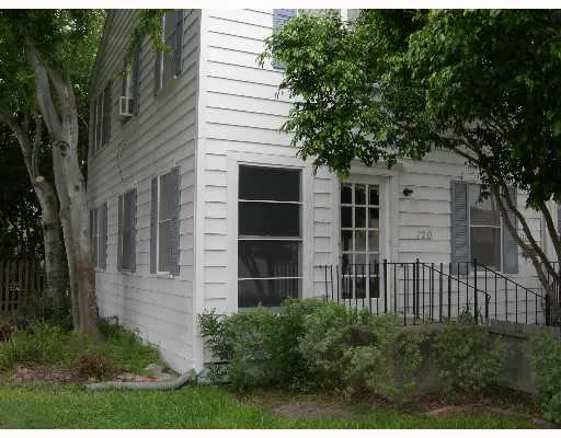 a view of a house with a large window and wooden fence