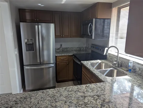 a kitchen with a refrigerator sink and cabinets
