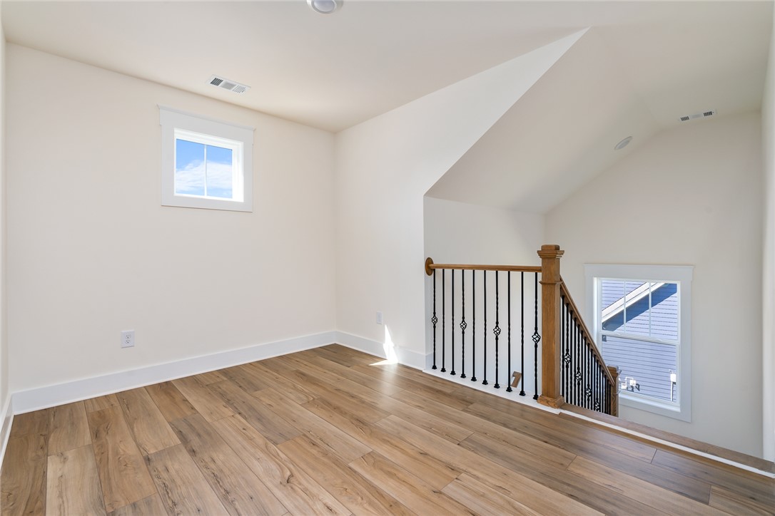 134 Ridgeline Row Central, SC 29630 - Photo 24 of 47 Bright and inviting space with warm wood flooring and elegant staircase details, perfect for modern living.