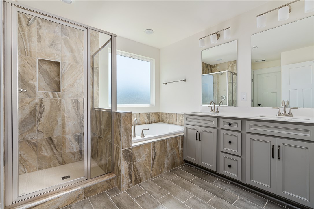 134 Ridgeline Row Central, SC 29630 - Photo 29 of 47 This primary bathroom features a double vanity, a shower, and a soaking tub.