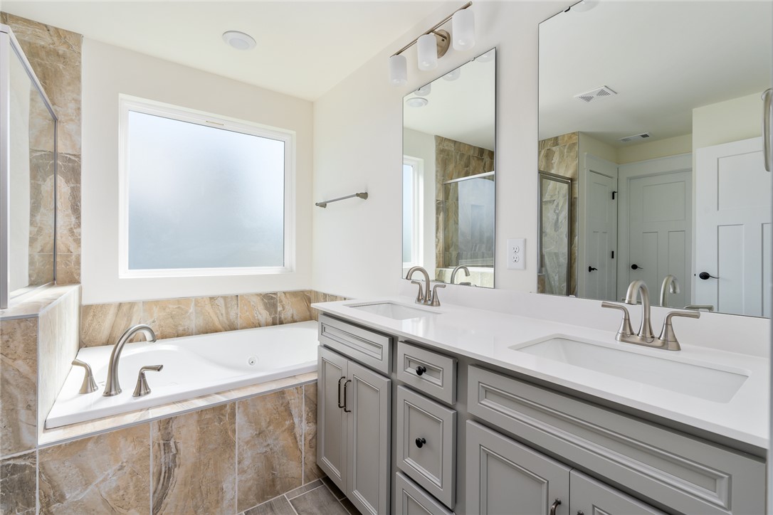 134 Ridgeline Row Central, SC 29630 - Photo 30 of 47 This primary bathroom features a double vanity and a soaking tub.