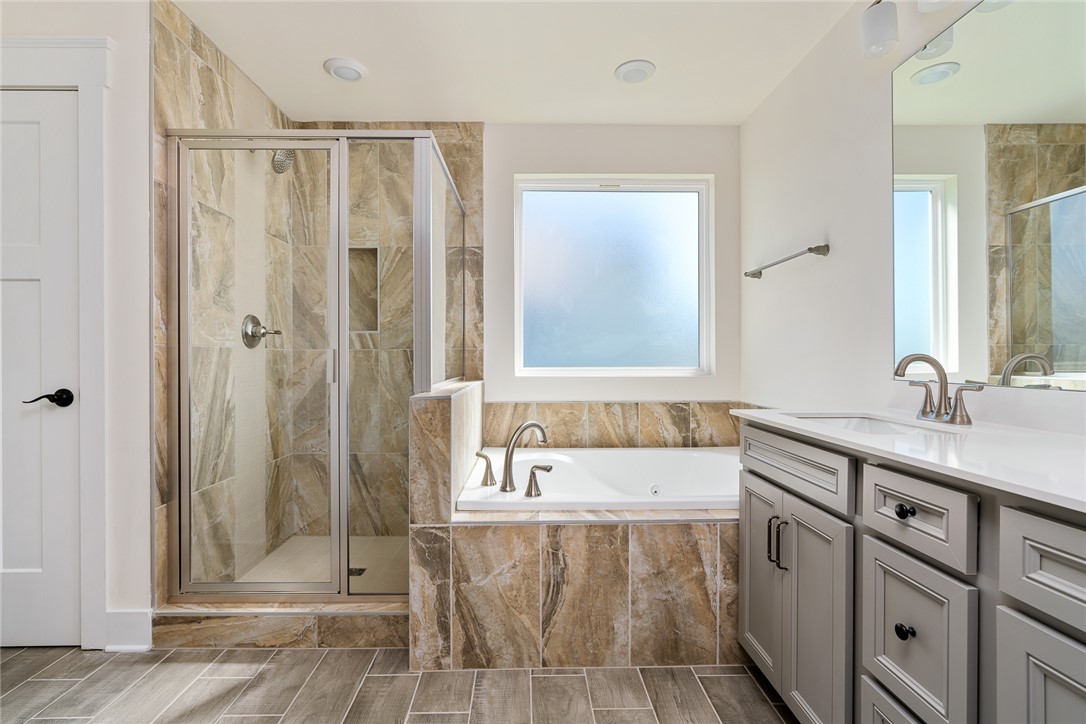 134 Ridgeline Row Central, SC 29630 - Photo 31 of 47 This primary bathroom offers a pristine shower, soaking tub, and elegant vanity with modern fixtures.