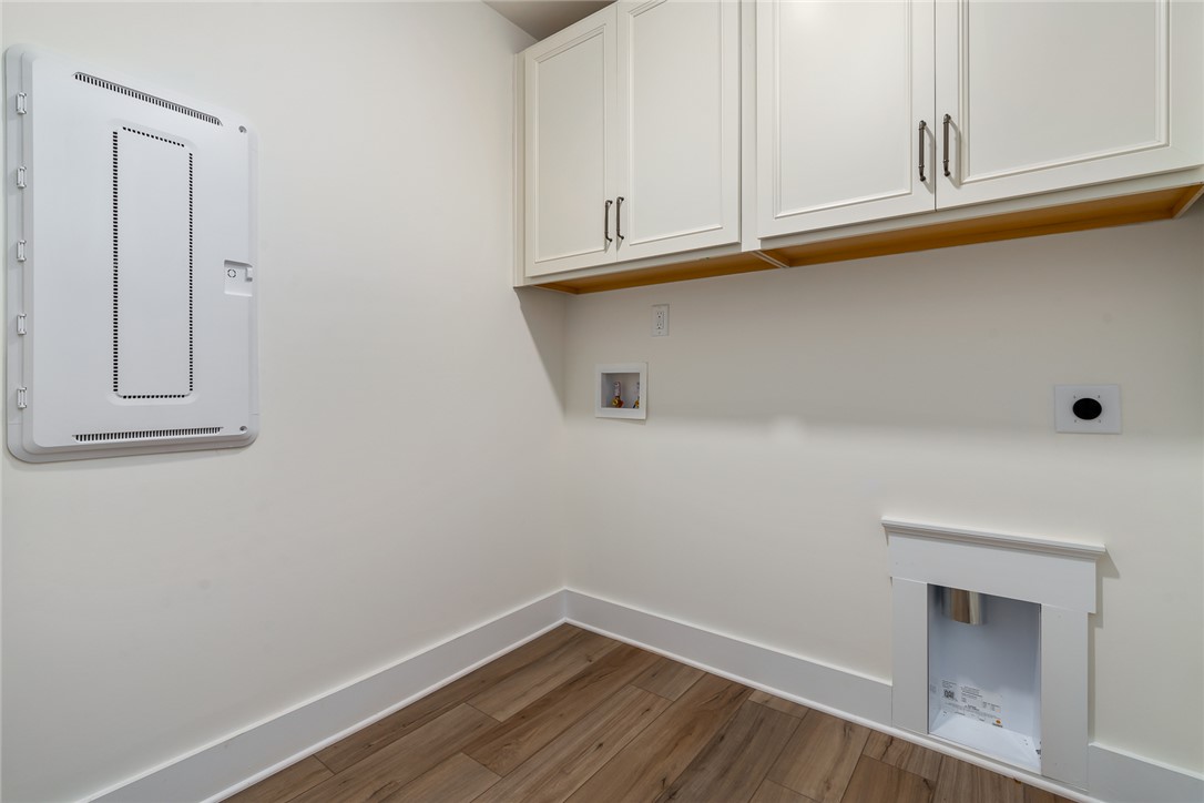 134 Ridgeline Row Central, SC 29630 - Photo 39 of 47 This laundry area features warm wood flooring and ample cabinetry for organized living.