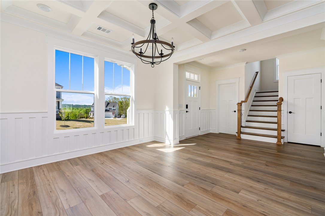 134 Ridgeline Row Central, SC 29630 - Photo 9 of 47 Bright and airy living space showcasing durable flooring and an elegant entryway with staircase.