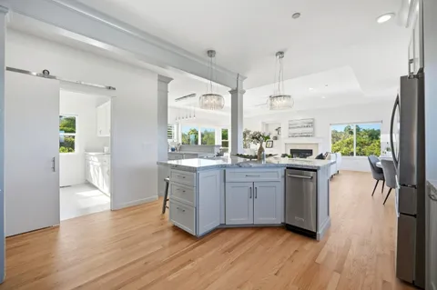 a kitchen with stainless steel appliances granite countertop wooden floors and white cabinets