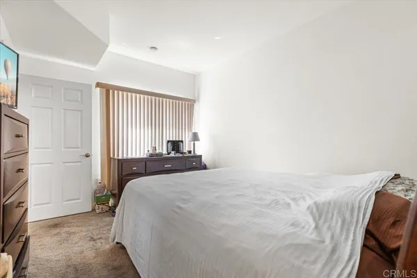 a bedroom with a bed and a refrigerator