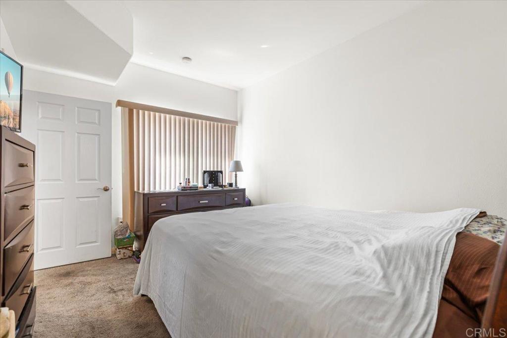 2715 Lake Pointe Drive, Unit 116 Spring Valley, CA 91977 - Photo 15 of 23 a bedroom with a bed and a refrigerator