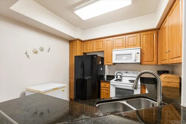 a kitchen with stainless steel appliances granite countertop a refrigerator sink and stove