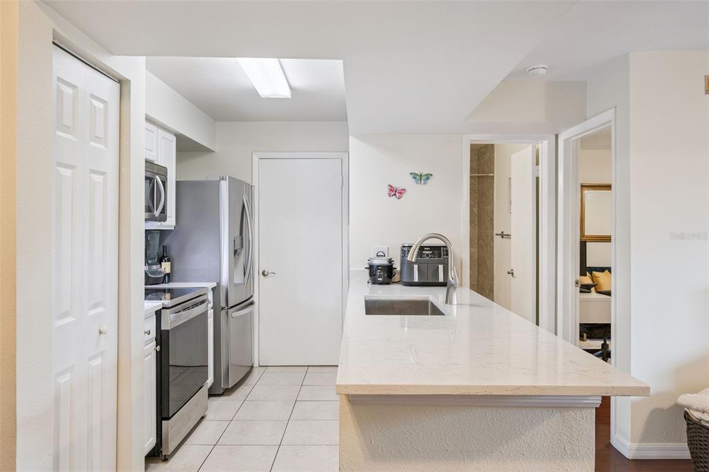 3032 Parkway Boulevard, Unit 305 Kissimmee, FL 34747 - Photo 10 of 40 a kitchen with stainless steel appliances granite countertop a refrigerator and a sink