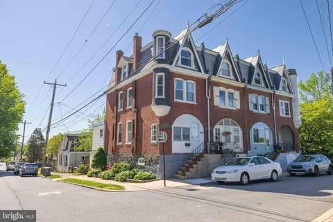 a front view of a building with cars