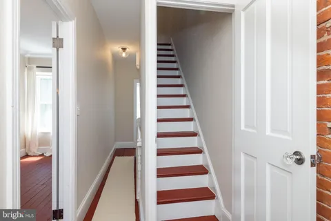 a view of a hallway with entryway and stairs