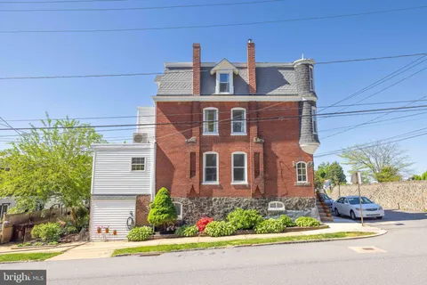 a front view of a house with a yard and potted plants