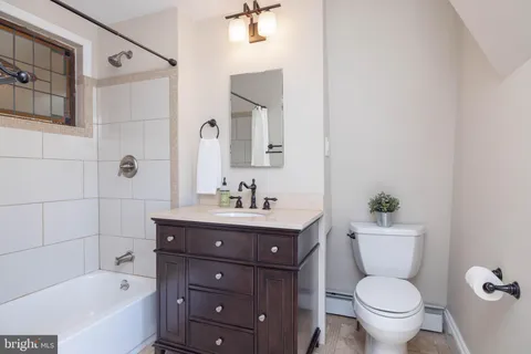 a bathroom with a granite countertop toilet a sink and a bathtub