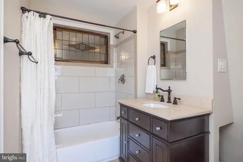 a bathroom with a sink mirror and a bathtub