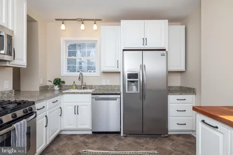 a kitchen with stainless steel appliances granite countertop a refrigerator stove and sink