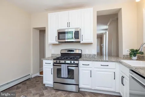 a kitchen with white cabinets and appliances