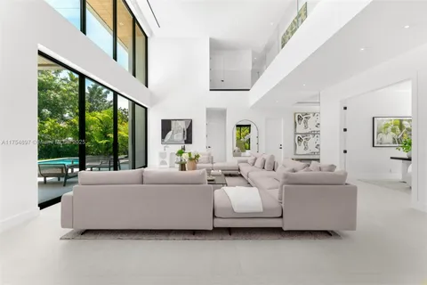 a living room with furniture and large windows