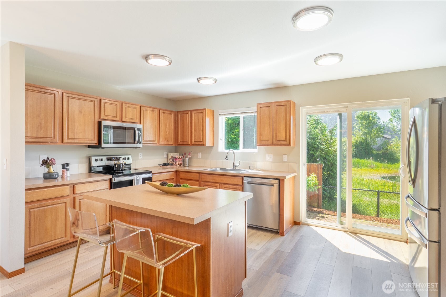 242 Riggs Drive East Enumclaw, WA 98022 - Photo 12 of 40 a kitchen with stainless steel appliances granite countertop a stove top oven a sink dishwasher a dining table and chairs with wooden floor