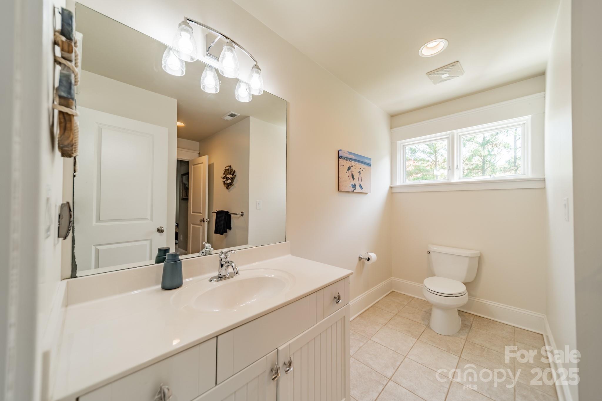 1946 Brawley School Road Mooresville, NC 28117 - Photo 34 of 48 a bathroom with a sink a toilet and a mirror