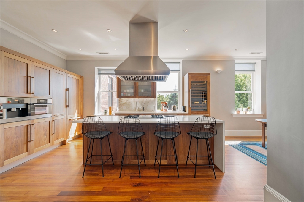 232 Summit Avenue, Unit A5 Brookline, MA 02446 - Photo 2 of 21 a kitchen with a dining table chairs and white cabinets