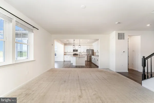 a large white kitchen with kitchen island a stove a sink dishwasher and a fireplace with wooden floor
